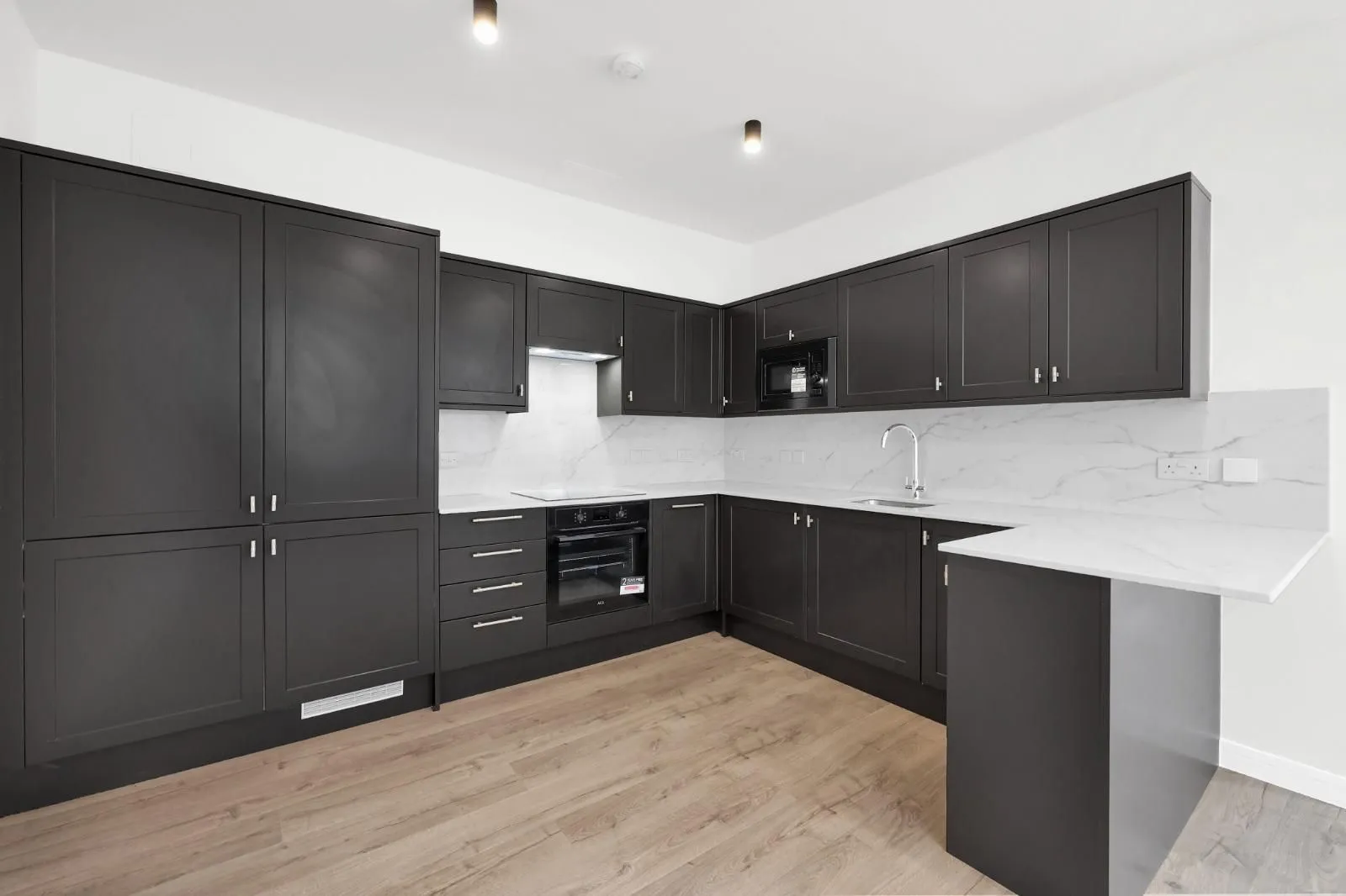 Professionally refurbished dark kitchen with a central island